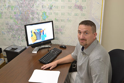 man sitting behind a desk with a computer on it