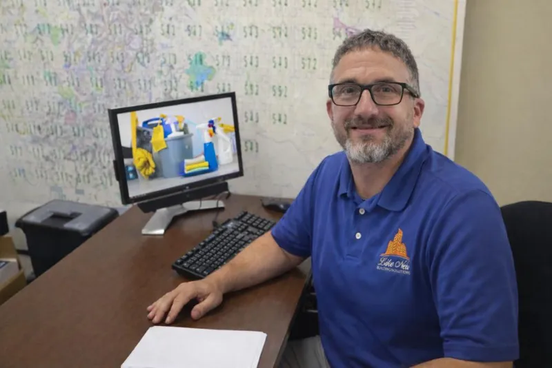 man sitting behind a desk with a computer on it